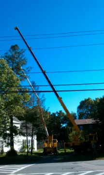 A crane is in the air next to power lines.