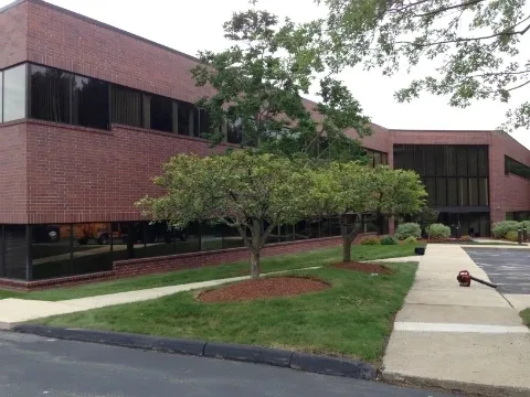 A building with trees and grass in front of it.