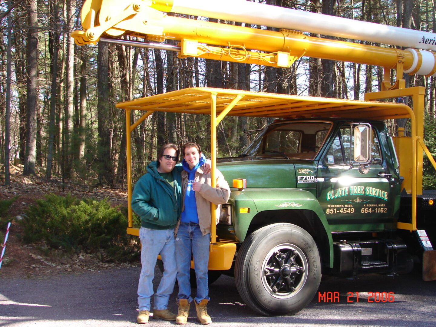 Two people standing in front of a green truck.