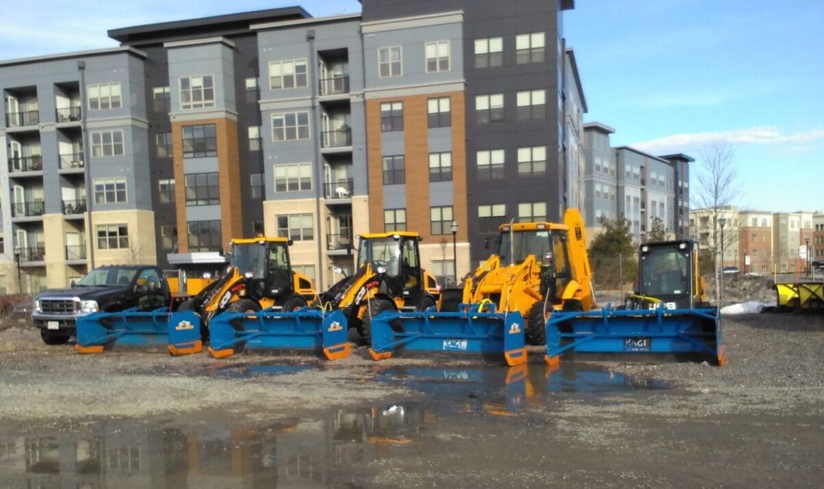 A group of construction equipment parked in the street.